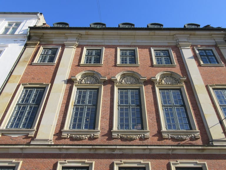 Fasaden på Kronprinsessegade 4 i Köpenhamn, ett tegelhus med ljusa stenomfattningar och höga spröjsade fönster