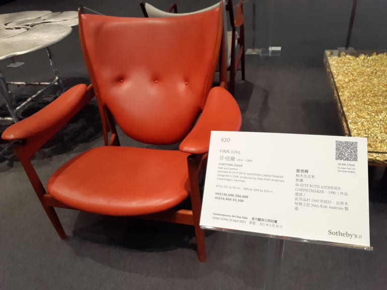 Chieftain Chair i teak med orangerött läder och tre knappar i ryggen, med Sotheby’s utställningsetikett
