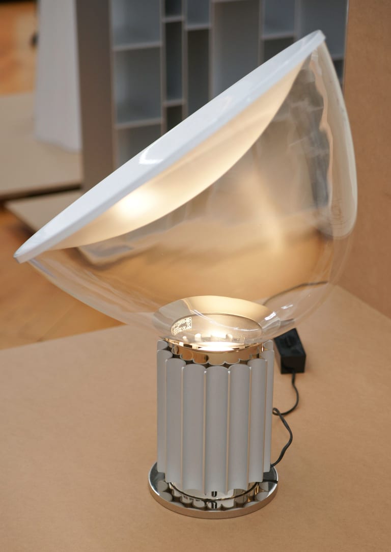 Bordslampan Taccia av Achille och Pier Giacomo Castiglioni för Flos, med en skål i klart glas och vit reflektor på en räfflad cylindrisk fot