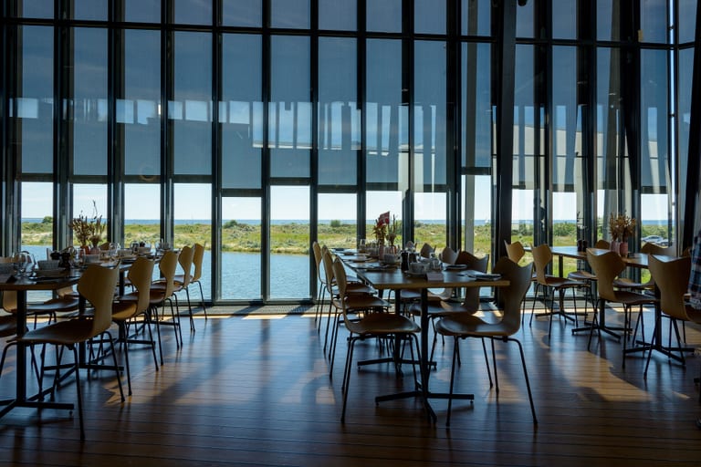 Grand Prix-stolar av Arne Jacobsen för Fritz Hansen, med stålben, kring dukade bord i restaurangen på ARKEN i Ishøj