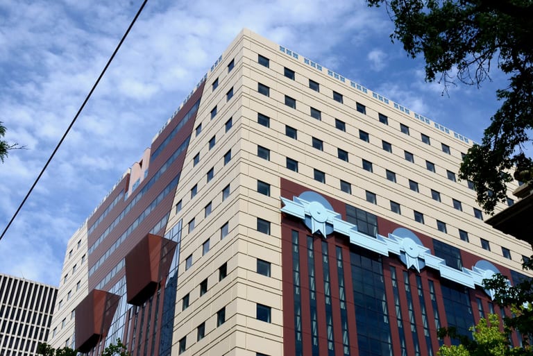 Övre delen av Portland Building i Portland, Oregon, med ljusa fasadplattor, rödbruna fält och ljusblå reliefer formade som girlanger