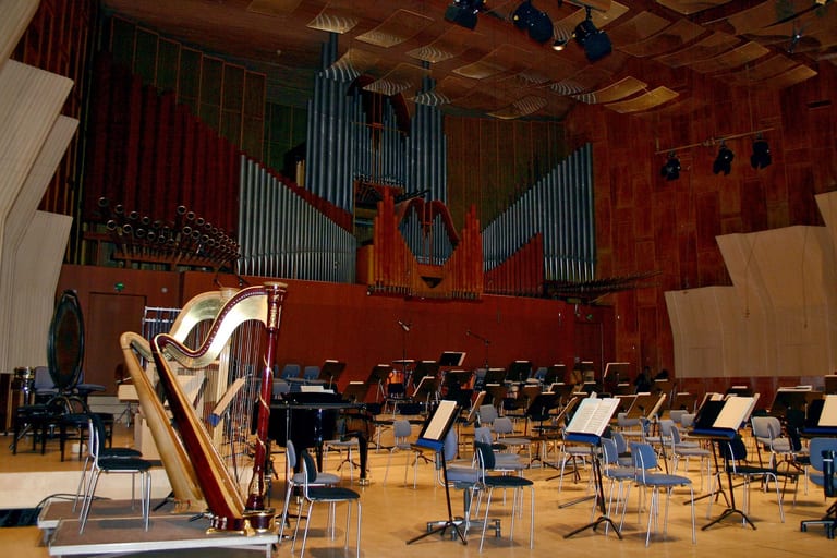 Radiohusets konsertsal sedd från podiet, med orgelpipor, väggar och tak klädda i trä, böjda akustikpaneler och orkesterns stolar och notställ